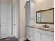 Bathroom with white cabinets, granite countertop, and large framed mirror at 20199 Sweetwood Ln, Clermont, FL 34715