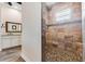 Modern shower room with stacked stone details and pebble floor in a luxurious bathroom at 20199 Sweetwood Ln, Clermont, FL 34715