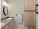 Bathroom featuring double vanity, walk-in shower with decorative tile, and modern fixtures at 20199 Sweetwood Ln, Clermont, FL 34715