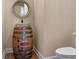 Bathroom featuring a Jack Daniels barrel vanity with round mirror and a modern toilet at 20199 Sweetwood Ln, Clermont, FL 34715