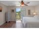 Bright bedroom with balcony access, white bedding, and views of the golf course at 20199 Sweetwood Ln, Clermont, FL 34715