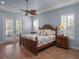 Bedroom with a wooden bed frame, two side tables, and French doors to a patio at 20199 Sweetwood Ln, Clermont, FL 34715