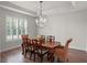 Bright dining room with a unique chandelier, wood table and chair set with shuttered window at 20199 Sweetwood Ln, Clermont, FL 34715