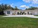 Sprawling single-story home with a large driveway and well-manicured lawn at 20199 Sweetwood Ln, Clermont, FL 34715