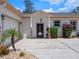 Inviting home entrance with a charming front door, stone accents, and lush landscaping at 20199 Sweetwood Ln, Clermont, FL 34715