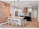 Spacious kitchen boasts white cabinetry, granite countertops, brick accent wall and a large island with seating at 20199 Sweetwood Ln, Clermont, FL 34715