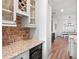 A kitchen with granite countertops, red-brick backsplash, and a built-in wine cooler and wine rack at 20199 Sweetwood Ln, Clermont, FL 34715