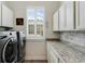 Well-lit laundry room with modern washer and dryer, counter space, and ample storage cabinets at 20199 Sweetwood Ln, Clermont, FL 34715