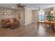 Spacious living room with wood floors, a comfortable couch, a desk, and two ceiling fans at 20199 Sweetwood Ln, Clermont, FL 34715