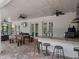 Spacious covered patio with an outdoor kitchen, bar seating, and a wooden dining table for entertaining at 20199 Sweetwood Ln, Clermont, FL 34715