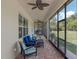 Long screened patio with brick flooring, ceiling fans, and comfortable seating arrangements at 20199 Sweetwood Ln, Clermont, FL 34715
