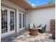 Cozy outdoor patio with a stone fire pit and comfortable seating next to French doors at 20199 Sweetwood Ln, Clermont, FL 34715