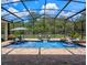 Inviting screened-in pool area with stylish lounge furniture, flowing fountains, and lush landscaping at 20199 Sweetwood Ln, Clermont, FL 34715