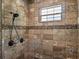 Stone tiled shower stall features a pebble border and a window for natural light at 20199 Sweetwood Ln, Clermont, FL 34715