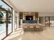 Modern living room with bar seating, wood floors, built-in shelving, and large windows overlooking pool at 213 Breezeway Dr, Davenport, FL 33897