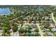 An aerial view of a residential area surrounded by lush trees, and water in the background, highlighting the community at 226 Selkirk Way, Longwood, FL 32779