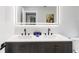 Modern bathroom features a double sink vanity with matte black faucets and a large illuminated mirror at 226 Selkirk Way, Longwood, FL 32779