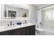 Modern bathroom features a double sink vanity with matte black faucets, a large illuminated mirror, and bathtub at 226 Selkirk Way, Longwood, FL 32779