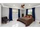 Bright bedroom featuring marble floors, blue curtains and a modern ceiling fan at 226 Selkirk Way, Longwood, FL 32779