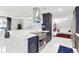 Modern kitchen with island, stainless steel appliances, marble counters, and blue cabinets at 226 Selkirk Way, Longwood, FL 32779