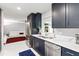 Bright kitchen featuring navy blue cabinets, stainless steel appliances, and white marble flooring at 226 Selkirk Way, Longwood, FL 32779
