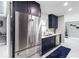 Modern kitchen boasts navy cabinets, stainless appliances, and white marble countertops at 226 Selkirk Way, Longwood, FL 32779