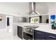 Modern kitchen featuring stainless steel appliances, marble counters, and blue cabinets at 226 Selkirk Way, Longwood, FL 32779