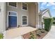 Charming front porch with a bright blue door and beautiful landscaping at 231 Chestnut Creek Dr, Apopka, FL 32703