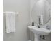 Clean powder room features a white pedestal sink, round mirror, and towel bar at 231 Chestnut Creek Dr, Apopka, FL 32703