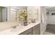 Bathroom with dual sinks, quartz countertops, and access to walk-in closet at 7542 Headwaters Ct, Groveland, FL 34736