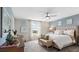 Comfortable primary bedroom with tufted headboard, ceiling fan, and abundant natural light at 7542 Headwaters Ct, Groveland, FL 34736