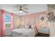 Bedroom with pink walls, ceiling fan, modern art, and a comfortable bed at 7542 Headwaters Ct, Groveland, FL 34736