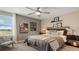 Cozy bedroom with large window, ceiling fan, sports-themed decorations and a comfortable king-sized bed at 7542 Headwaters Ct, Groveland, FL 34736