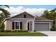 Charming single-story home with a well-maintained lawn and two car garage at 245 Streamliner Way, Groveland, FL 34736