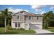 Two-story home with gray siding, light green shutters, a manicured lawn, and a two-car garage at 7542 Headwaters Ct, Groveland, FL 34736