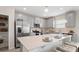 Modern kitchen featuring stainless steel appliances, gray cabinets, a large quartz island, and barstool seating at 7542 Headwaters Ct, Groveland, FL 34736