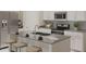 Modern kitchen with stainless steel appliances, an island with seating, and sleek countertops at 245 Streamliner Way, Groveland, FL 34736