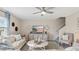 Bright living room with neutral furnishings, stairs to the second floor, and a large entertainment center at 7542 Headwaters Ct, Groveland, FL 34736