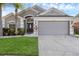 Charming home featuring a well-manicured lawn, tropical landscaping and a two-car garage at 2520 Oakington St, Winter Garden, FL 34787