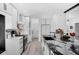 Modern kitchen with white cabinetry, black marble countertops, and sleek, stainless steel appliances at 2520 Oakington St, Winter Garden, FL 34787