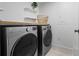 Updated laundry room featuring front load washer and dryer with wood shelf and decor at 2742 Sun Key Pl, Kissimmee, FL 34747