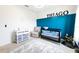 Bedroom with blue paneled accent wall, crib, changing table, chair and batman toys at 2752 Grand Central Ave, Tavares, FL 32778