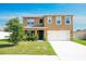 Inviting two-story home featuring a two-car garage, covered entry, and fresh landscaping at 2752 Grand Central Ave, Tavares, FL 32778