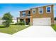 Welcoming two-story home with a two-car garage, covered porch, and well-maintained front yard at 2752 Grand Central Ave, Tavares, FL 32778