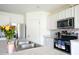 Well-lit kitchen showcasing stainless steel appliances, white cabinets, and a tiled backsplash at 2752 Grand Central Ave, Tavares, FL 32778