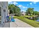 Backyard features a lawn, a pond, and a patio with chairs and a grill at 2776 Joseph Cir, Oviedo, FL 32765