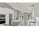 Open-concept kitchen with stainless appliances, a central island, and views of a serene pond at 2776 Joseph Cir, Oviedo, FL 32765