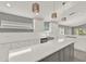 Modern kitchen featuring gray island, white cabinets, quartz countertop and decorative lighting fixtures at 2776 Joseph Cir, Oviedo, FL 32765