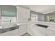 Bright kitchen featuring stainless steel farmhouse sink, quartz countertops and white cabinets at 2776 Joseph Cir, Oviedo, FL 32765