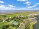 Expansive aerial showcasing community with lush landscaping, tennis courts, and stunning lake views under a partly cloudy sky at 2801 Boat Cove Cir, Kissimmee, FL 34746
